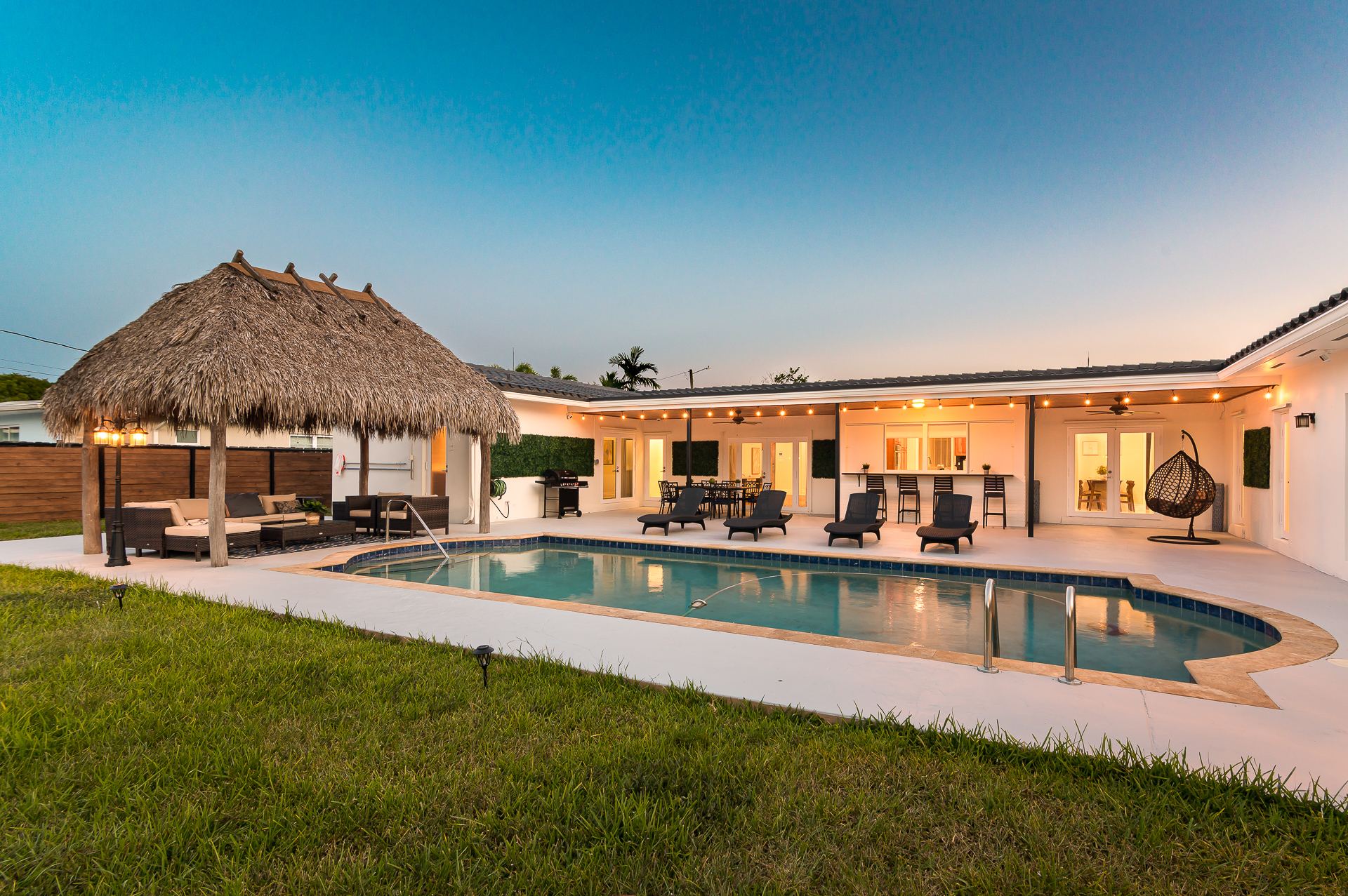 StayRnR-renovated villa with heated pool and tiki bar in Hollywood, Florida at dusk