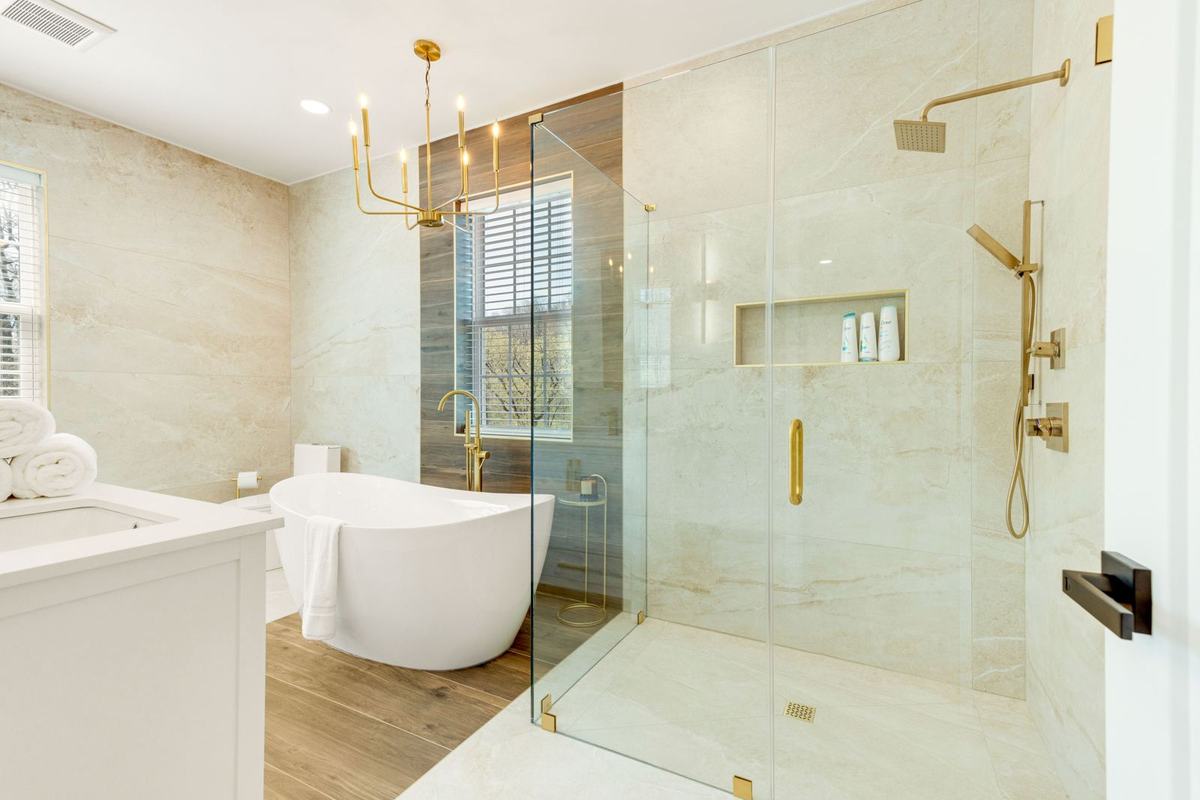 Renovated bathroom with freestanding tub, glass shower, and brass fixtures